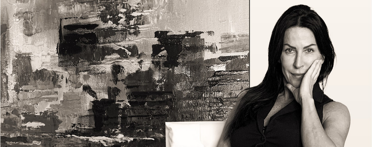Woman sitting on a couch in a room with black and white art on the wall
